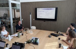 Photo shows a screen on a wall and a table covered with various devices